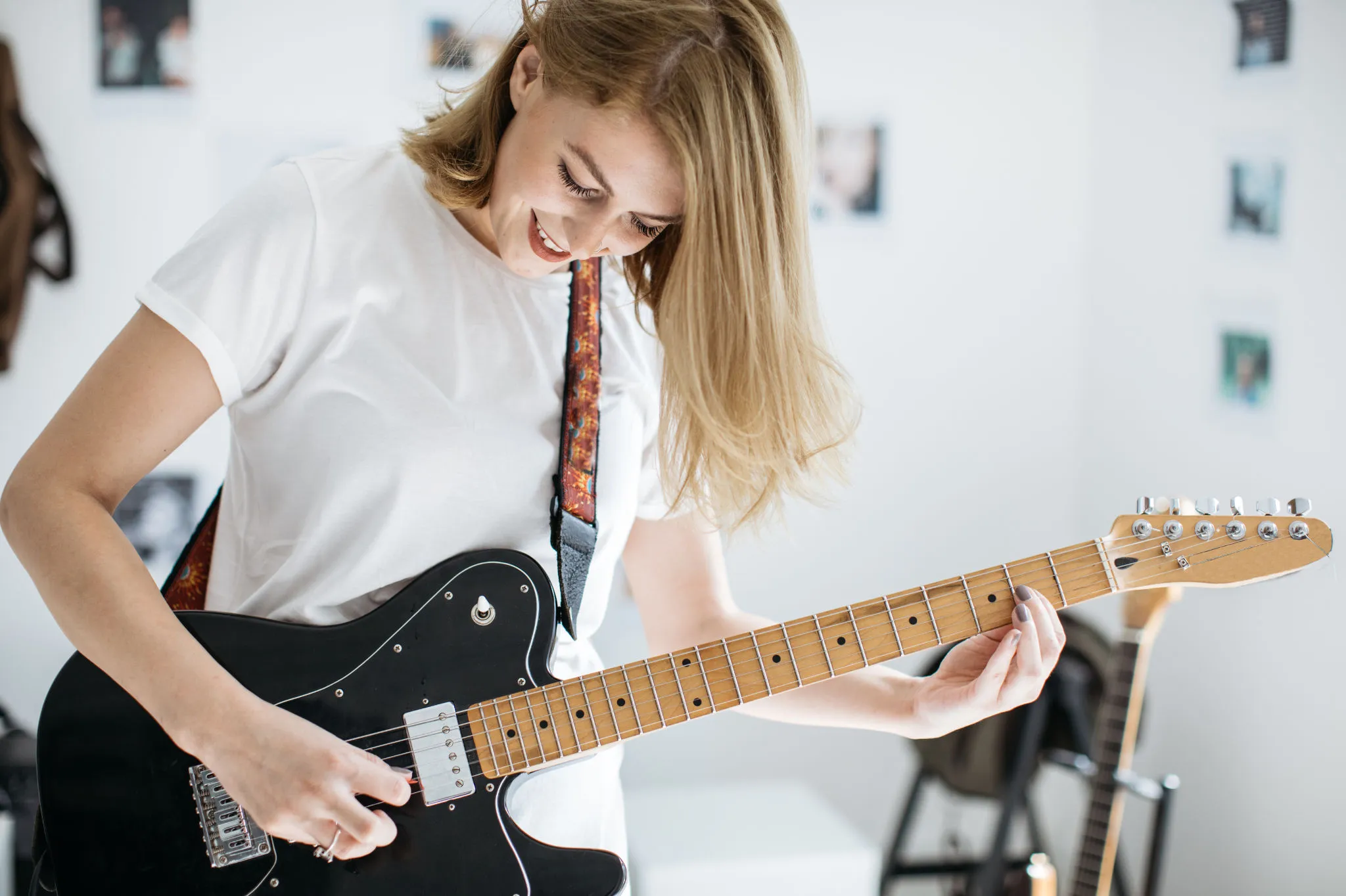 Lächelnde Frau spielt E-Gitarre
